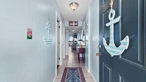 A hallway with a blue door, a patterned rug, and a 'thankful' sign. - OCEAN VIEW- PETS ALLOWED! (Myrtle Beach)