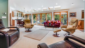 A spacious living room with leather sofas, a red couch, and a dining area with a table and chairs. - Idyllic NatureEstate, Pool, Jacuzi, PuttGreen, Gardens (Lagunitas-Forest Knolls)