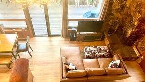 En hyggelig stue med sofa, pejs, fjernsyn og et spisebord med stole.