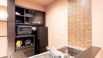 A compact kitchen with a microwave, oven, and sink.