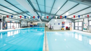 An indoor swimming pool with clear lanes, a reception area, and a large window on one side. - Fluffy Caravan Sleeps 4, Pet-Friendly (Isle of Sheppey)