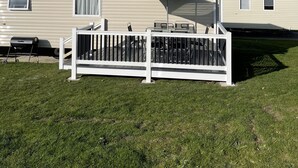 A mobile home with a fenced patio area, a grill, and a covered seating area. - Fluffy Caravan Sleeps 4, Pet-Friendly (Isle of Sheppey)