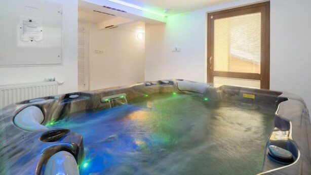 A room with a large, heated floor spa area, a whiteboard, and a window with blinds.