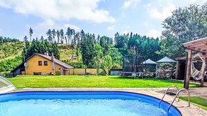 A swimming pool with a house and trees in the background.