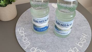 Two bottles of Krumbach water on a felt mat with text.