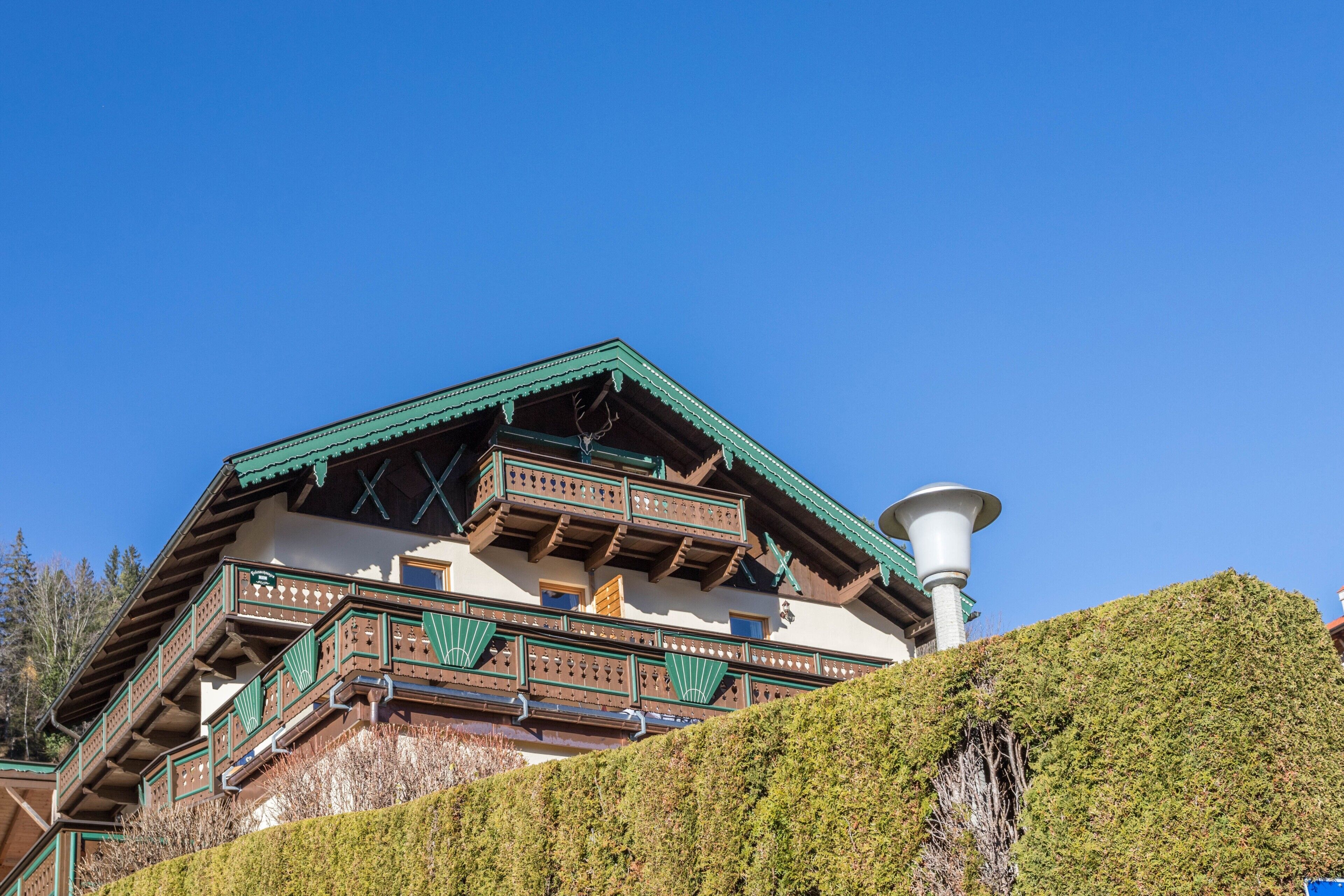 A traditional chalet with a steep roof, wooden balconies, and a chimney.
