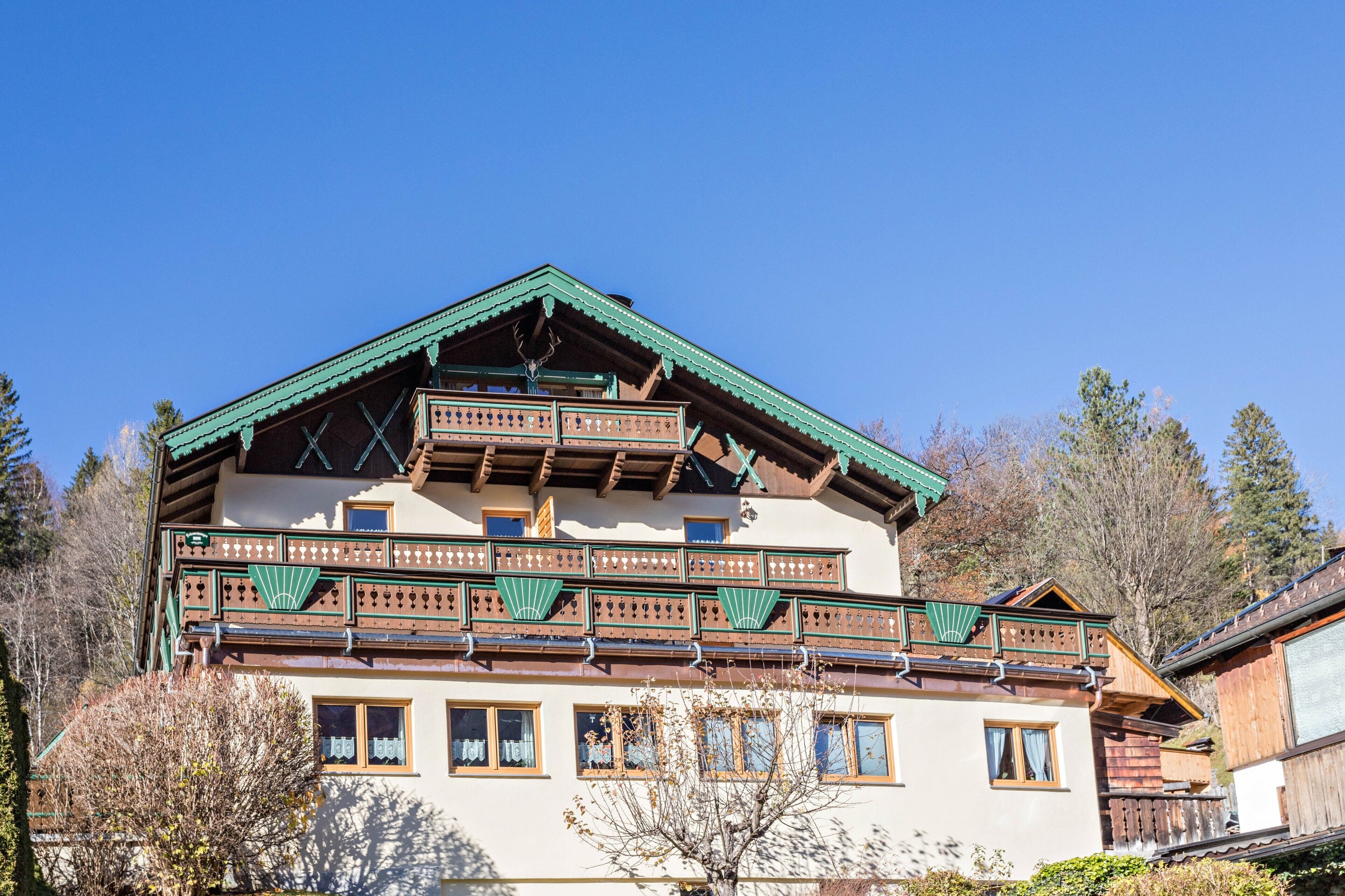 Un immeuble à plusieurs étages, doté de balcons, de rampes en bois et d’un toit à forte pente.