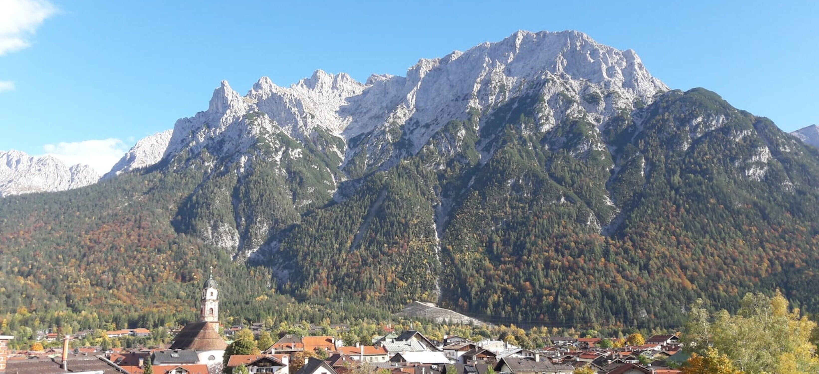 Un paysage de montagne avec une église et des immeubles d’habitation.