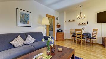 Un salon comprenant un canapé, une table basse et un coin repas avec des chaises et une table.