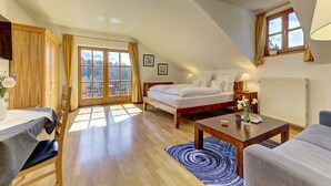Ein Schlafzimmer mit Bett, Schreibtisch, Stuhl, Tisch und einem Fenster mit Vorhängen.