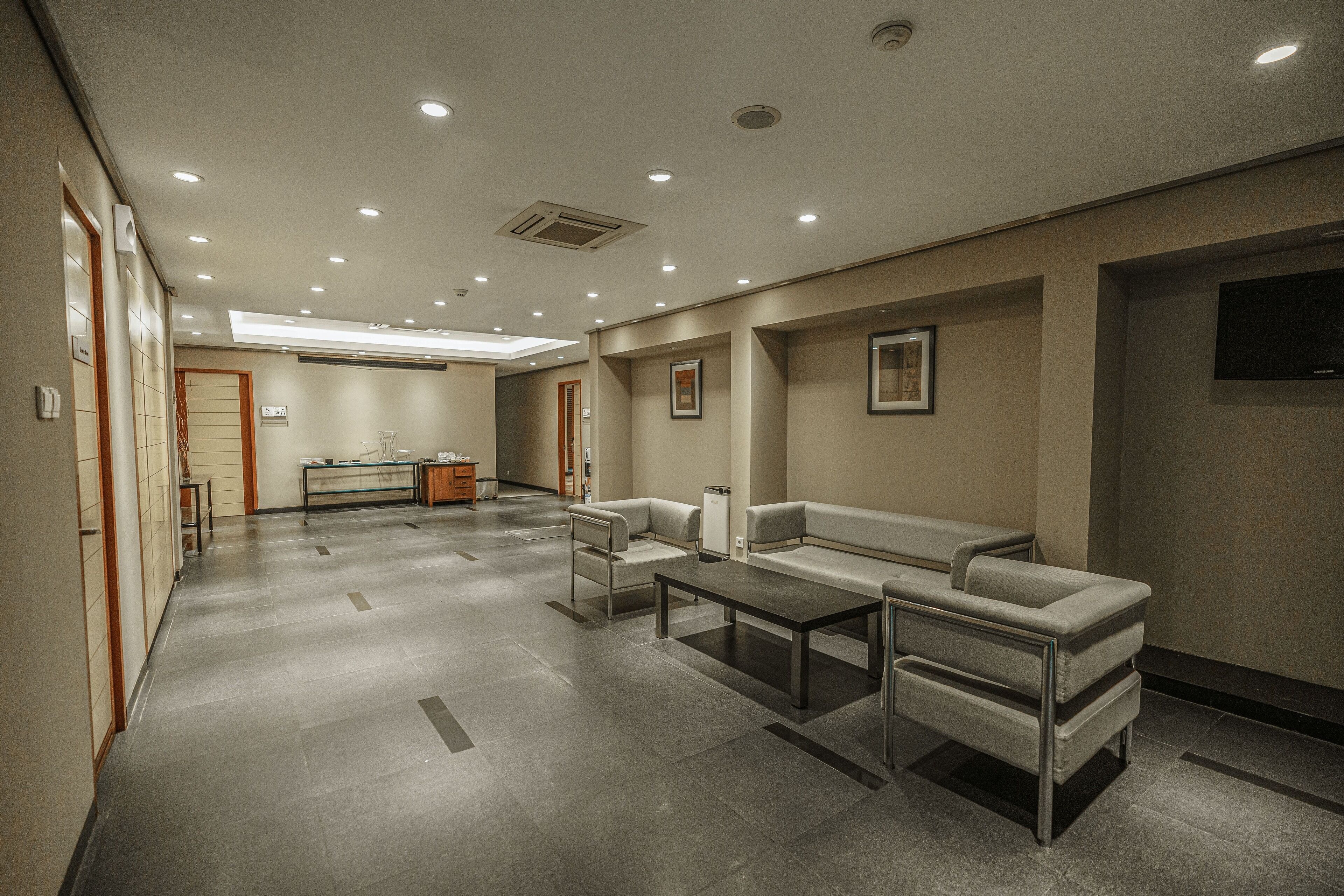 A modern waiting area with a sofa, a coffee table, and a reception desk.