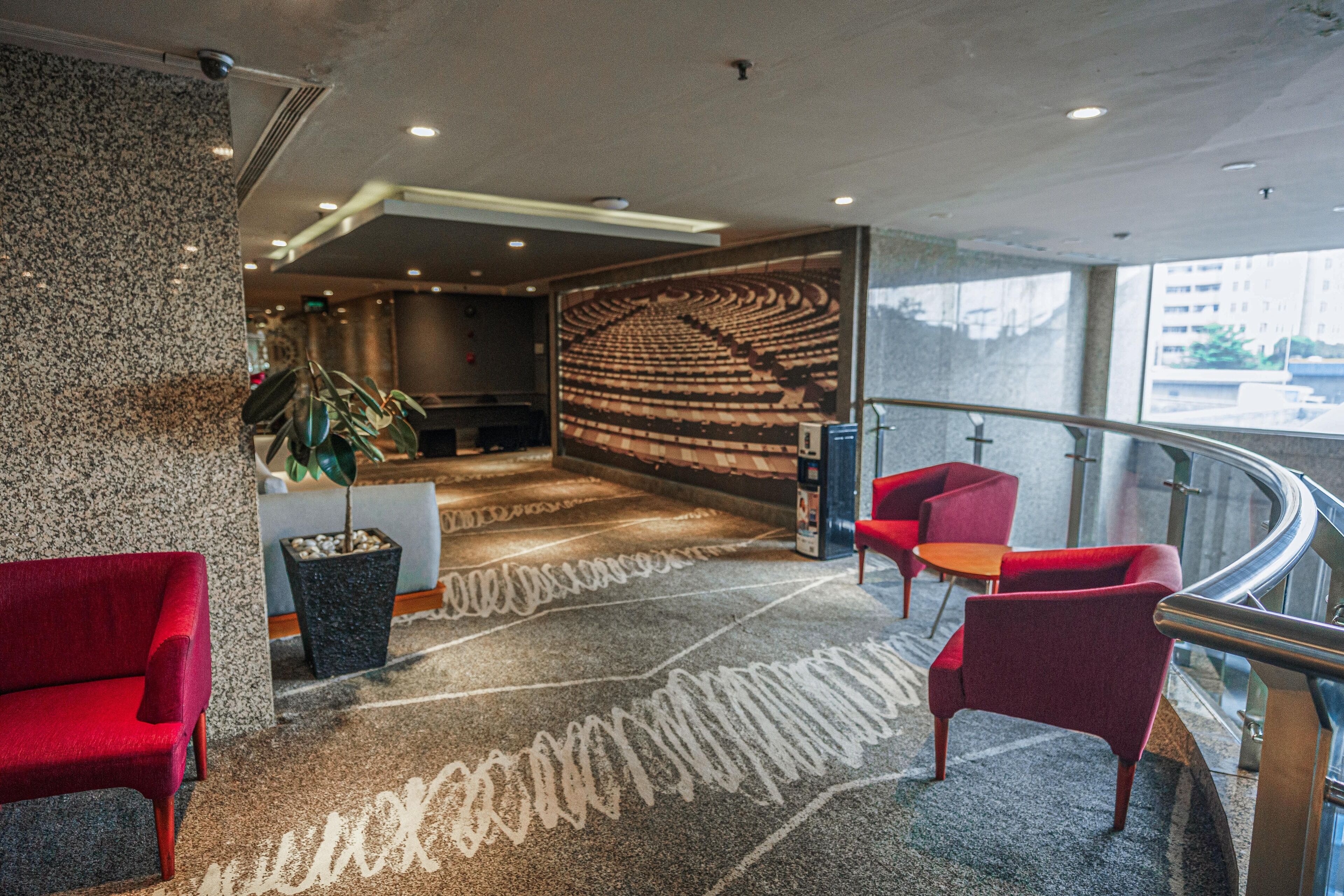 Um lobby com área de estar, balcão de recepção e um grande mural na parede.
