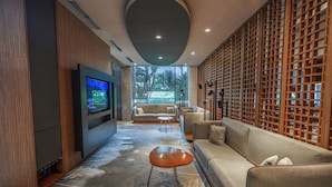 Uma sala de estar moderna com televisão de tela plana, um sofá, uma mesa de centro e um painel de madeira.