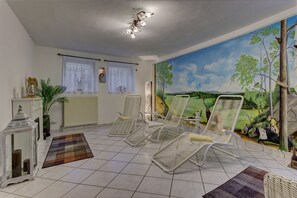 Relax in a serene space with a large window, vibrant mural, and comfortable lounge chairs.