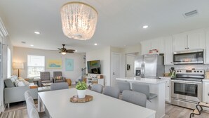 Una cocina moderna con armarios blancos, electrodomésticos de acero inoxidable y una isla central.