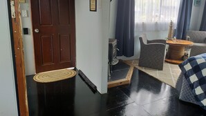 A living room with a wooden door, a fireplace, a sofa, and a coffee table.