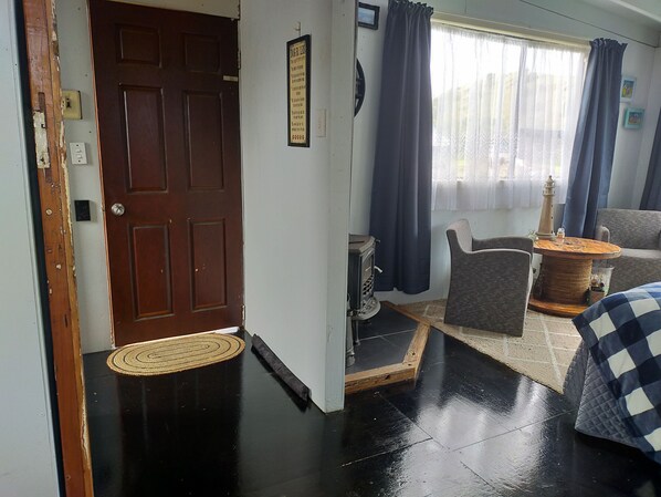 Una sala de estar con puerta de madera, chimenea, sofá y una mesa de centro.