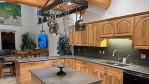 Une cuisine moderne avec des armoires en bois, des comptoirs en granit et des appareils électroménagers en acier inoxydable.