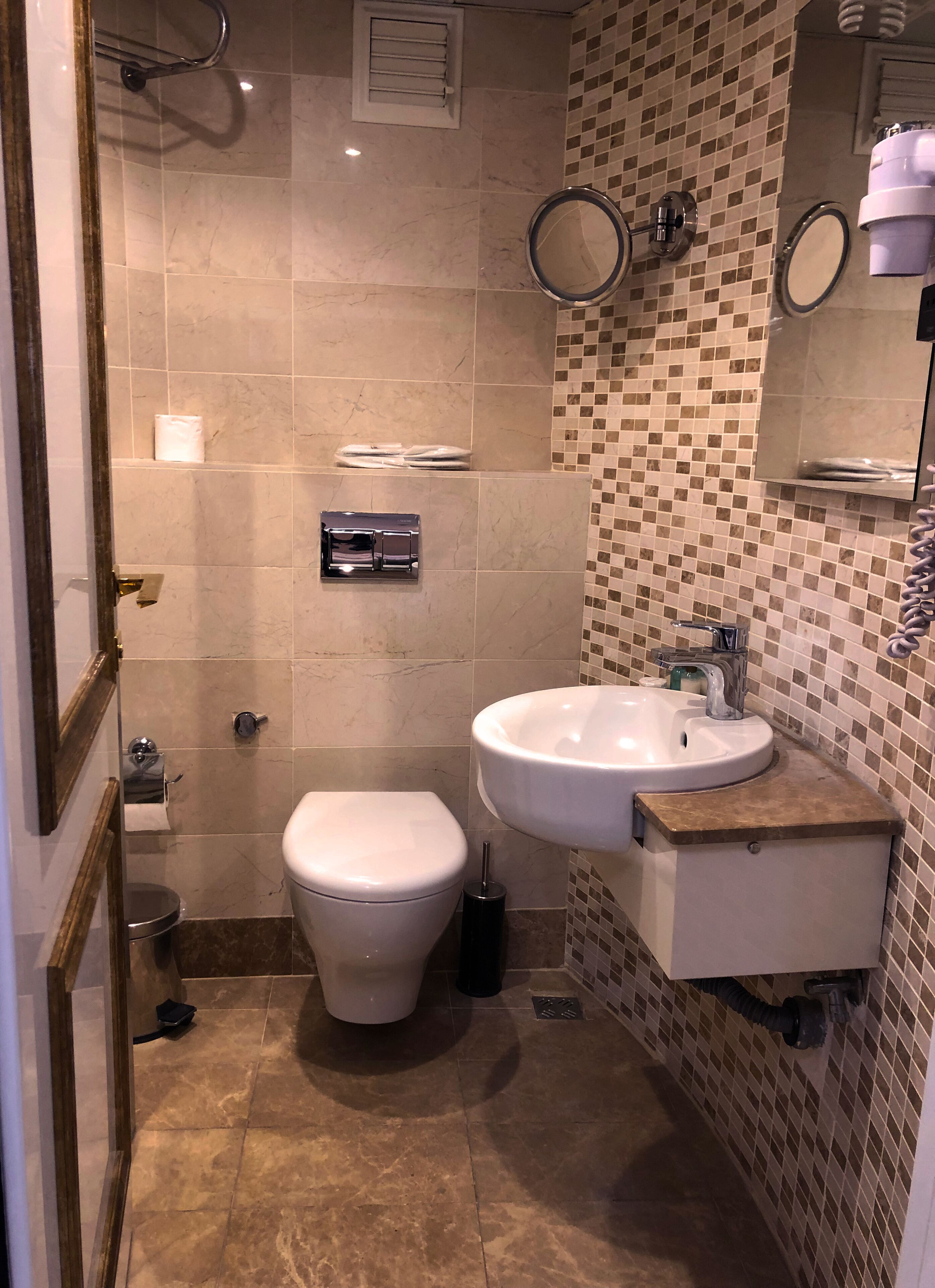 A bathroom with a toilet, sink, and shower.