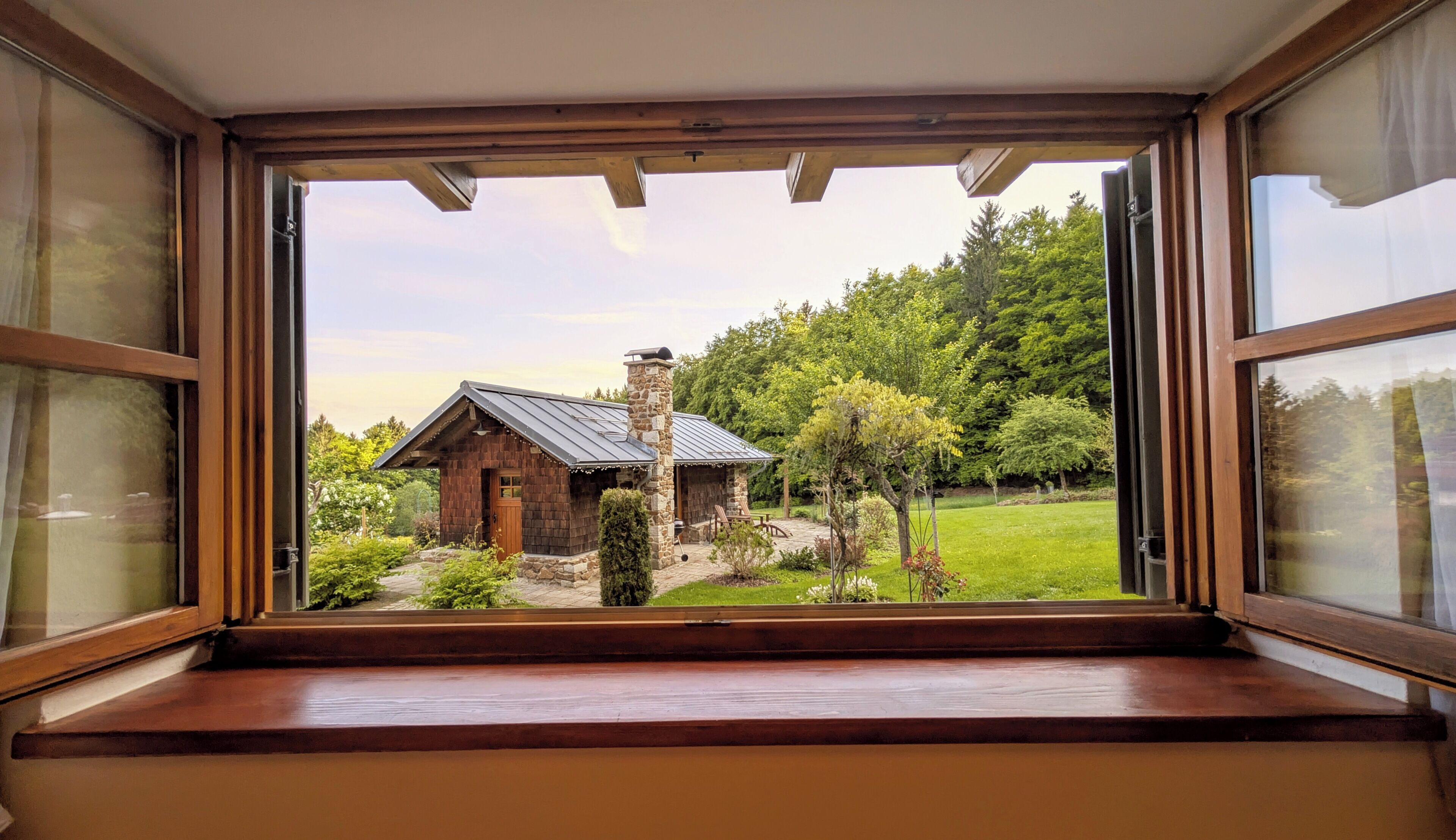 Eine hölzerne Bank mit Blick auf eine rustikale Holzhütte und einen Garten.