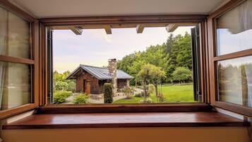 Eine hölzerne Bank mit Blick auf eine rustikale Holzhütte und einen Garten.