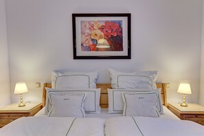 Una camera d'albergo con un letto matrimoniale, due comodini con lampade, un quadro incorniciato sopra il letto e una testiera in legno.
