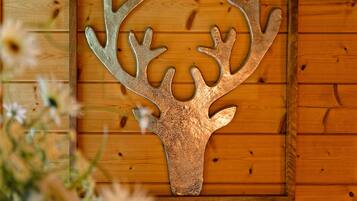 Une décoration murale représentant une tête de cerf, fixée sur un panneau en bois.