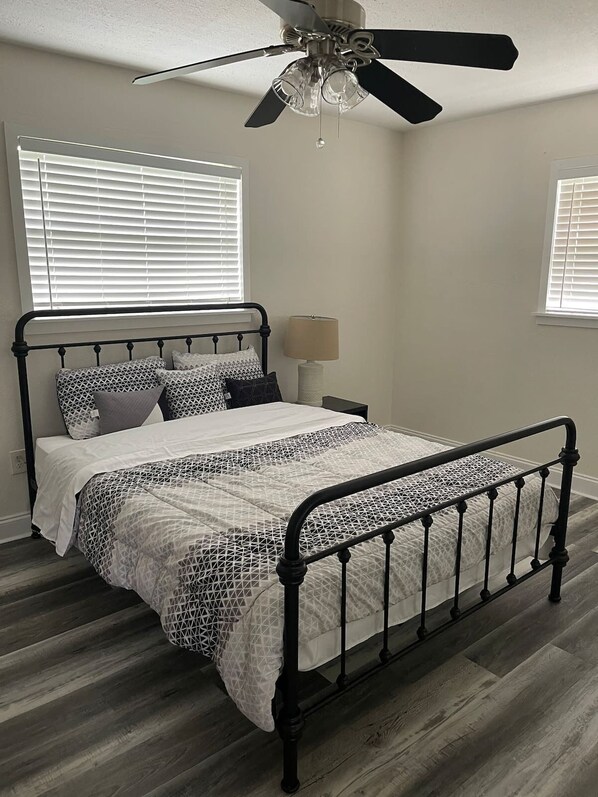 A bedroom with a metal bed frame, a ceiling fan, and two windows with blinds. - 3 bedroom House in a quiet neighborhood (Orlando)