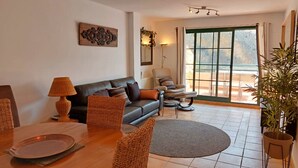 A living room with a sofa, armchairs, a coffee table, and a dining table. There is a large window with a view of the outdoors. - Casa Rousell - Altea, Costa Blanca (Altea)