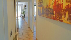 A hallway with a large painting of Venice, a tiled floor, and a door leading to another room. - Casa Rousell - Altea, Costa Blanca (Altea)