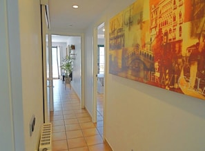 A hallway with a large painting of Venice, a tiled floor, and a door leading to another room. - Casa Rousell - Altea, Costa Blanca (Altea)