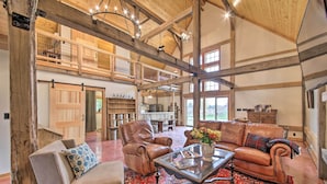 A spacious living area with leather sofas, a glass coffee table, and a red patterned rug. - Bloomington Cabin: 4 Mi to Indiana University (Bloomington)
