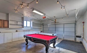 Enjoy a game of pool in this well-maintained indoor recreational area, featuring a pool table and ample lighting options.