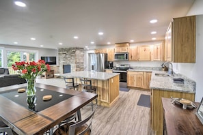 Enjoy cooking in this well-lit kitchen with a large island, appliances, and a view of the outdoors.