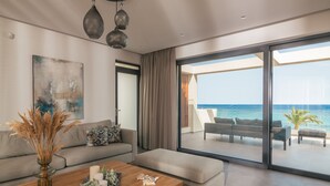 Una sala de estar moderna con un sofá, una mesa de centro y vistas al océano a través de grandes puertas de vidrio.
