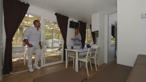 A room with a dining area, a sofa, and a TV. - Serene Stay by the Shore (Baia Domizia (CE))