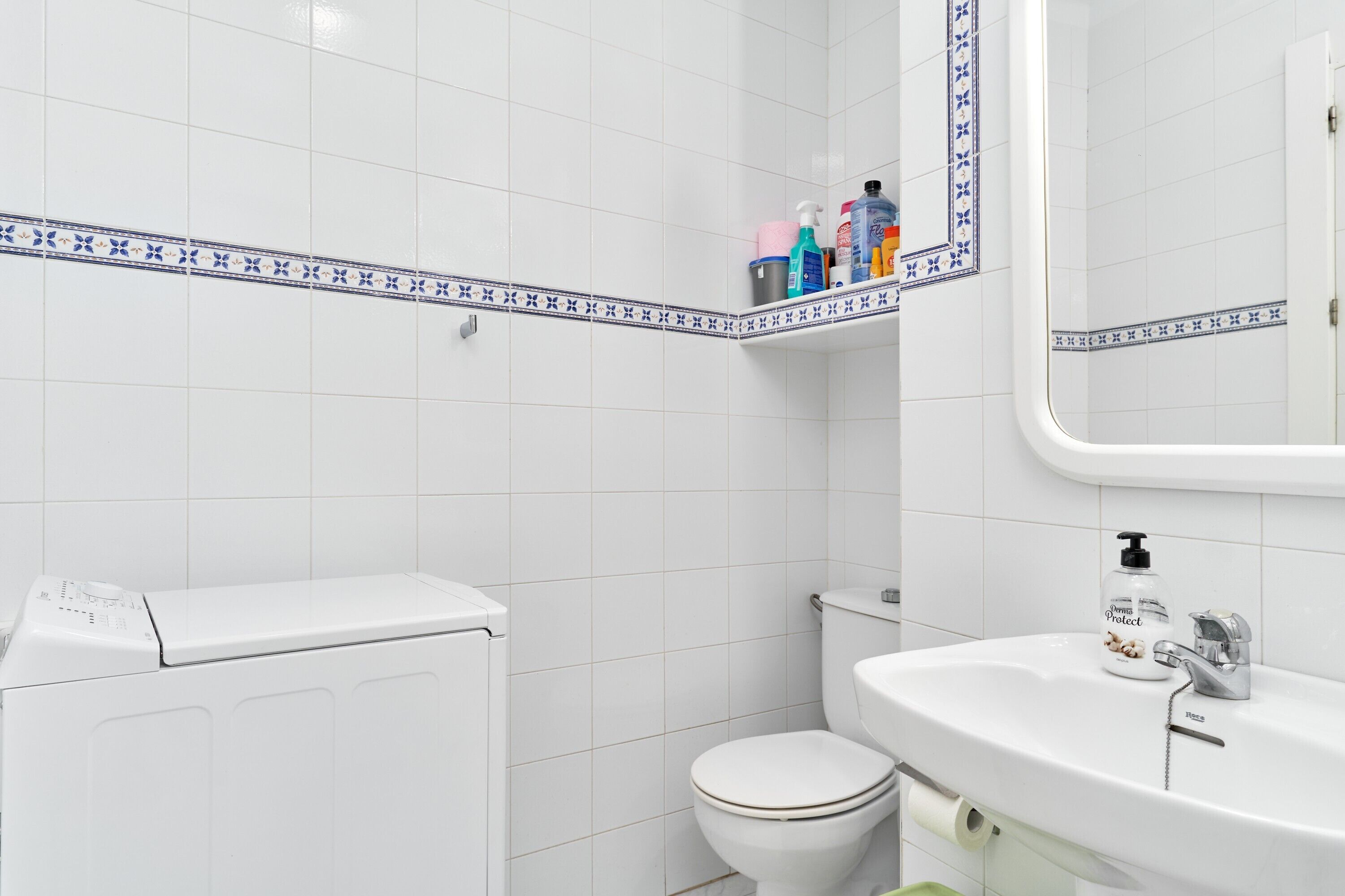 Ein Badezimmer mit Toilette, Waschbecken und einer Waschmaschine.
