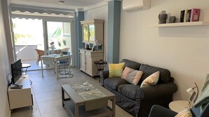 A living room with a sofa, armchair, coffee table, and a dining area with a table and chairs. - Holiday Apartment 'Wonderful Beach" with Sea View, Wi-Fi, Air Conditioning & Terrace (Nerja)