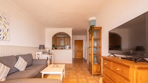A living room with a sofa, a coffee table, a TV, and a wooden cabinet. - 'Sunny Apartment Front Line Burriana' Near the Beach with Sea View, Wi-Fi, A/C & Balcony (Nerja)