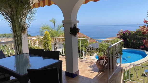 A covered outdoor area with a pool, seating, and a view of the sea. - Wonderful Villa Princessa with Sea & Mountain Views, Pool, and Wi-Fi (Nerja)