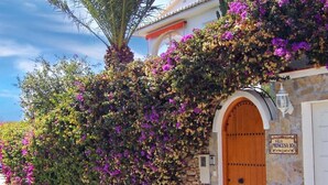 A villa with a stone wall, a wooden door, and a sign reading 'Villa Princesa 10'. - Wonderful Villa Princessa with Sea & Mountain Views, Pool, and Wi-Fi (Nerja)