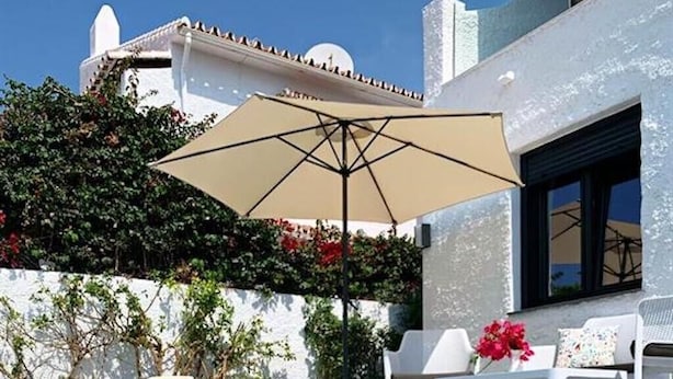 A swimming pool with lounge chairs and an umbrella, surrounded by white walls and greenery. - 'Wonderful House by the sea' with Sea & Mountain View, Pool and Wi-Fi (Nerja)