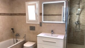Un bagno con vasca, WC, lavandino e doccia.