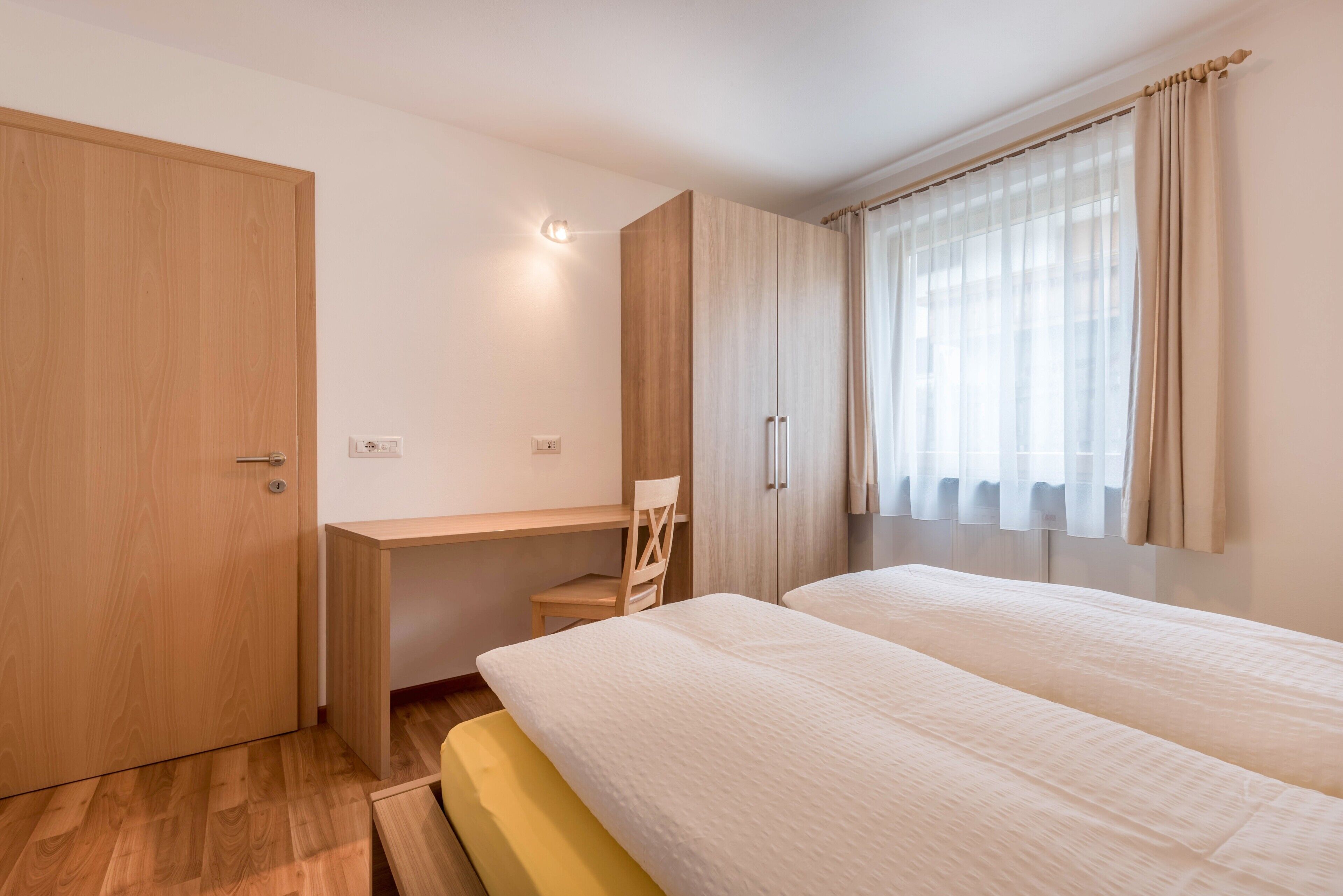 Une chambre à coucher avec un lit, un bureau et une armoire.