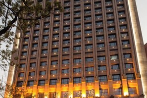 Edifício com várias andares, fachada uniforme e grade de janelas.