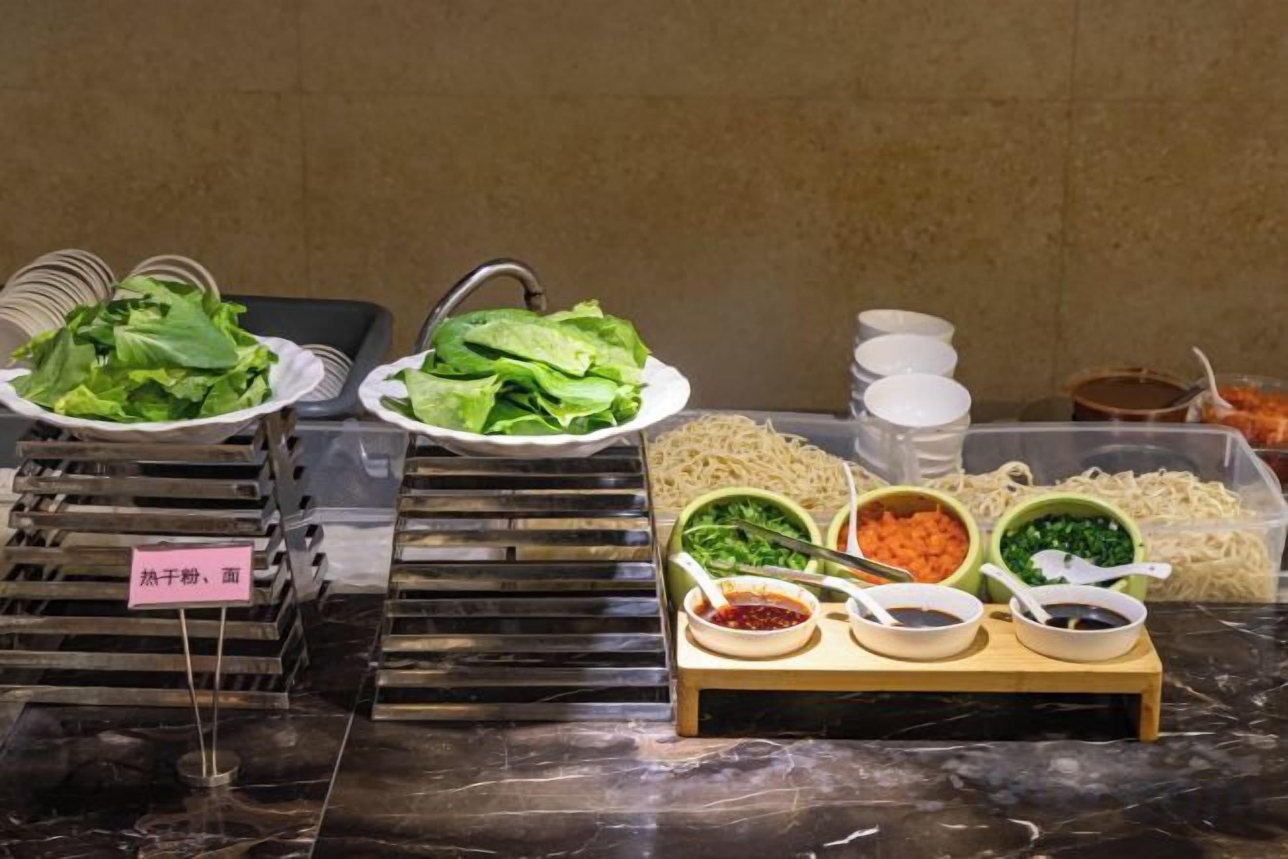 A buffet with various dishes and condiments.