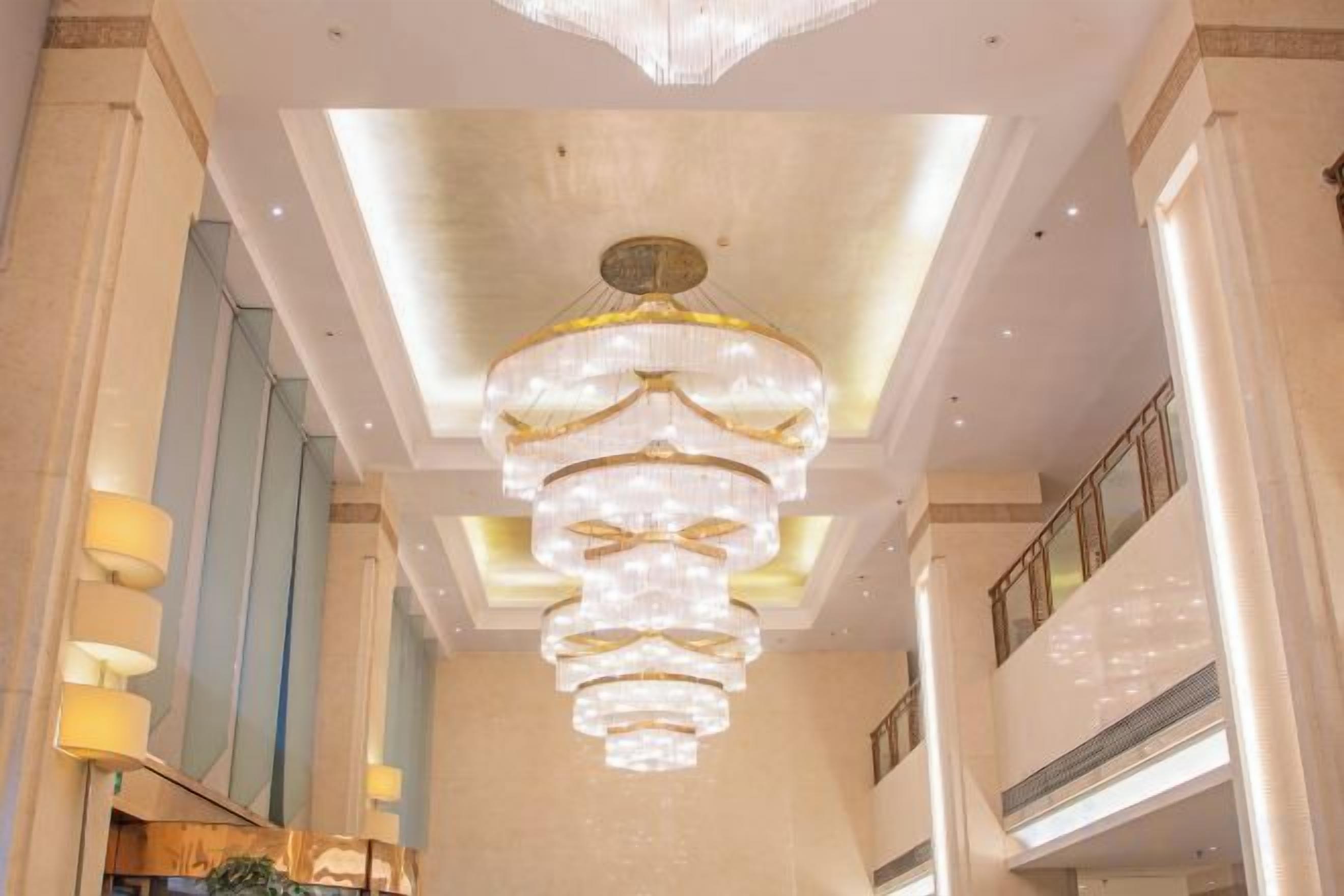 Un lampadario in un atrio d'hotel, con soffitto alto e ampie finestre.