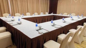 A conference room with a long table, chairs, water bottles, and nameplates.