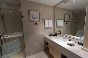 Une salle de bain moderne avec une douche à parois de verre, un lavabo avec un miroir et un porte-serviettes.