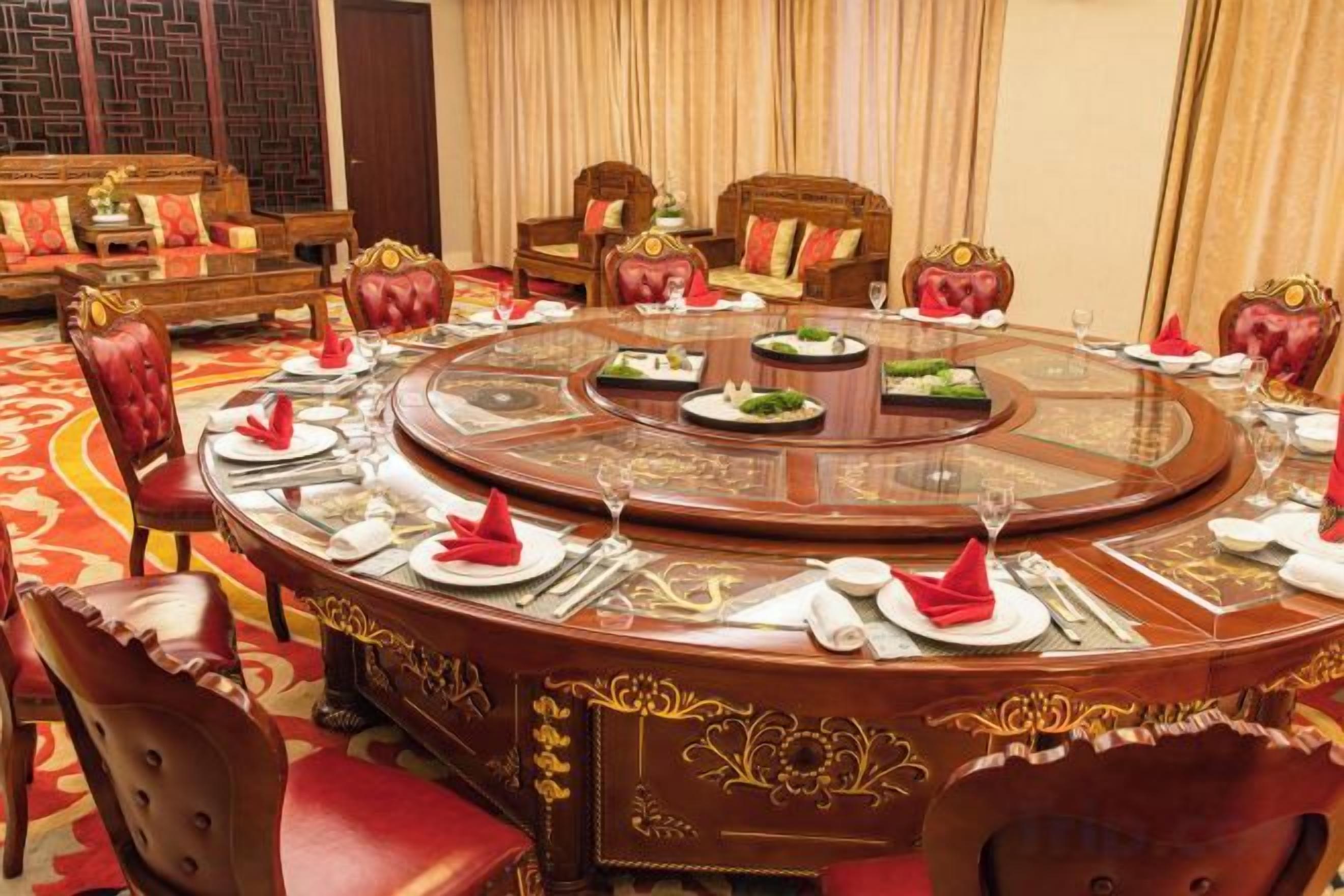 A round dining table with chairs, set for a meal.